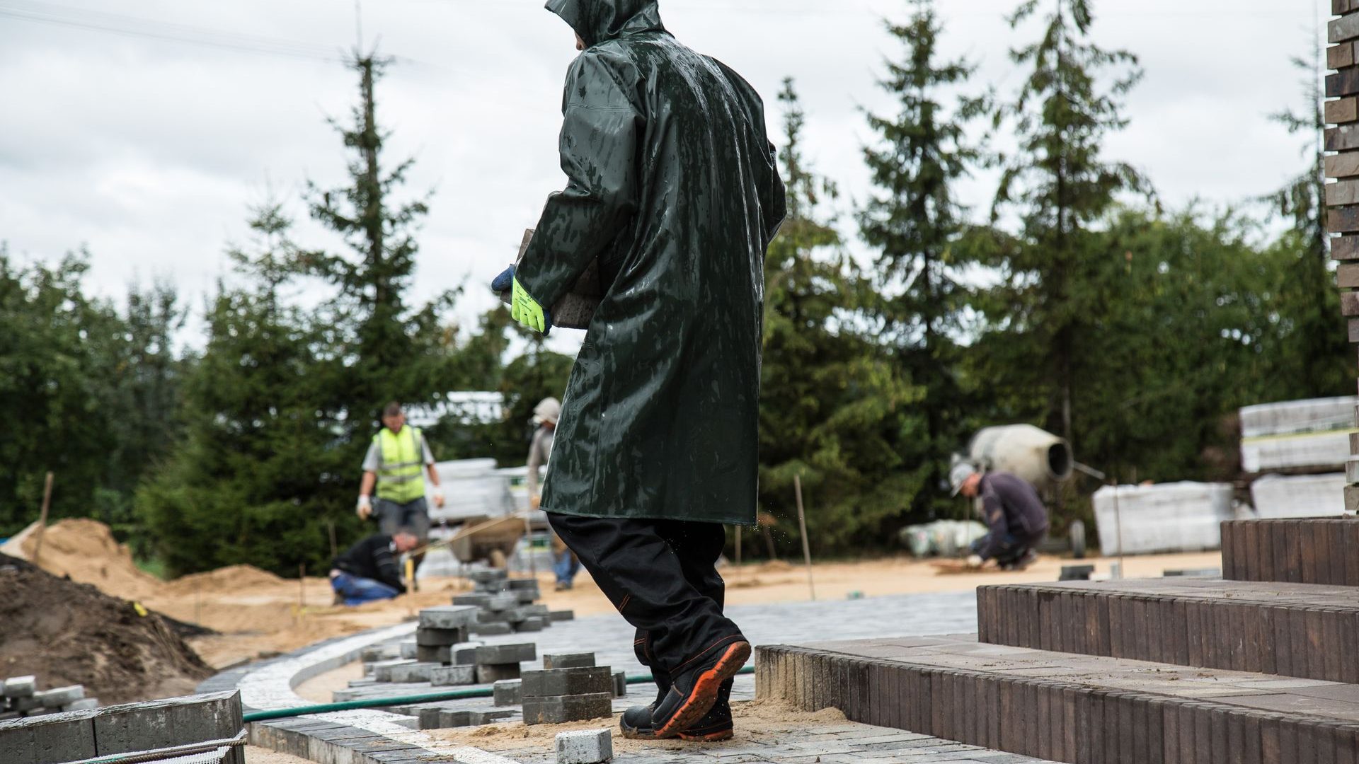 Arbeiter verlegt auf einer Baustelle Pflastersteine für eine Terrasse