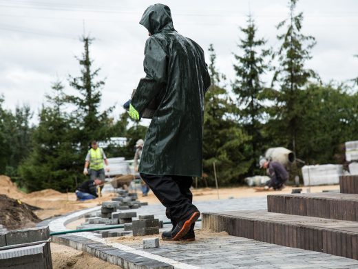 Arbeiter verlegt auf einer Baustelle Pflastersteine für eine Terrasse
