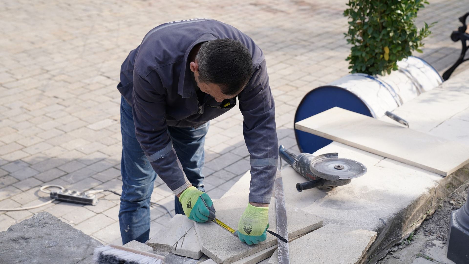 Handwerker schneidet Terrassenplatten zu und verlegt sie