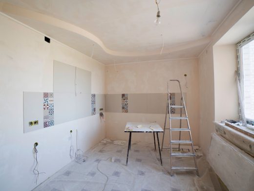 Hell verputzter Raum mit Leiter während der Wohnungssanierung