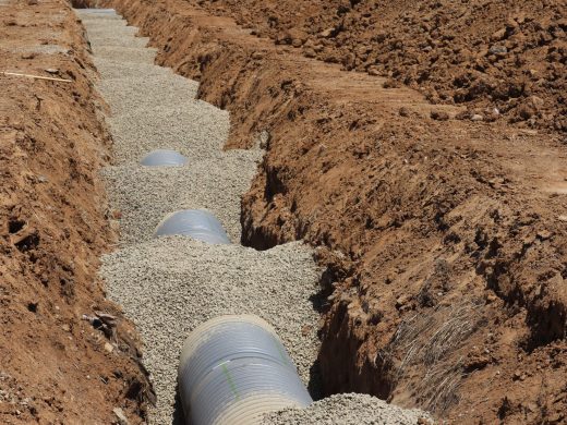 Drainagegraben mit eingebettetem Rohr und Kiesbett